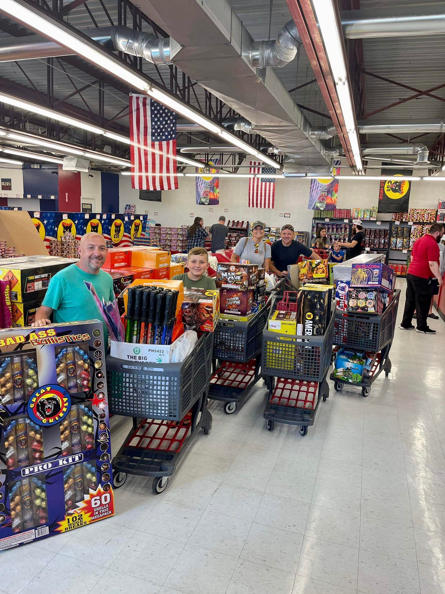 A group of people are shopping for fireworks in a store.