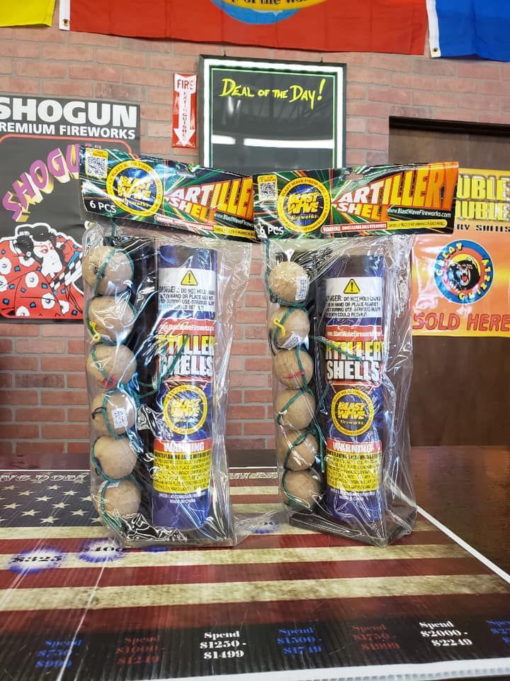 Two bags of fireworks are sitting on a table in front of a brick wall.