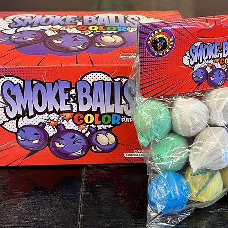 A box of smoke balls is sitting on a table next to a bag of smoke balls.