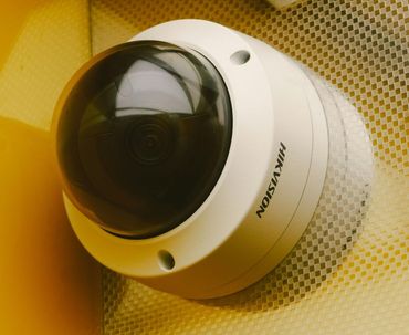 Uma câmera hikvision está sobre uma superfície amarela