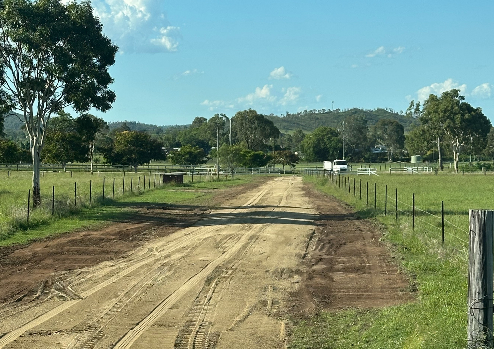 A dirt driveway in a Field With Trees In The Background — AMW Contracting Co In Cobraball, QLD