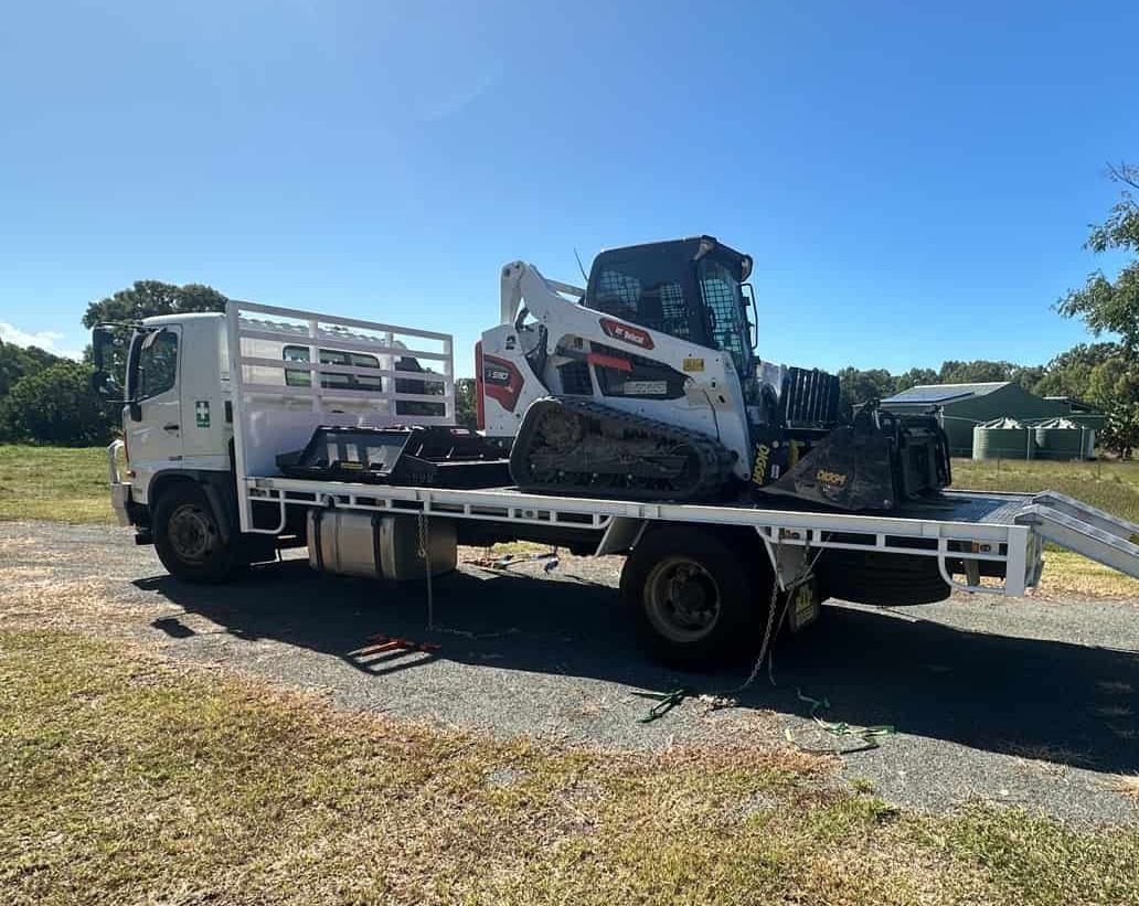 A Bulldozer Is Sitting On Top Of A Flatbed Truck — AMW Contracting Co In Cobraball, QLD