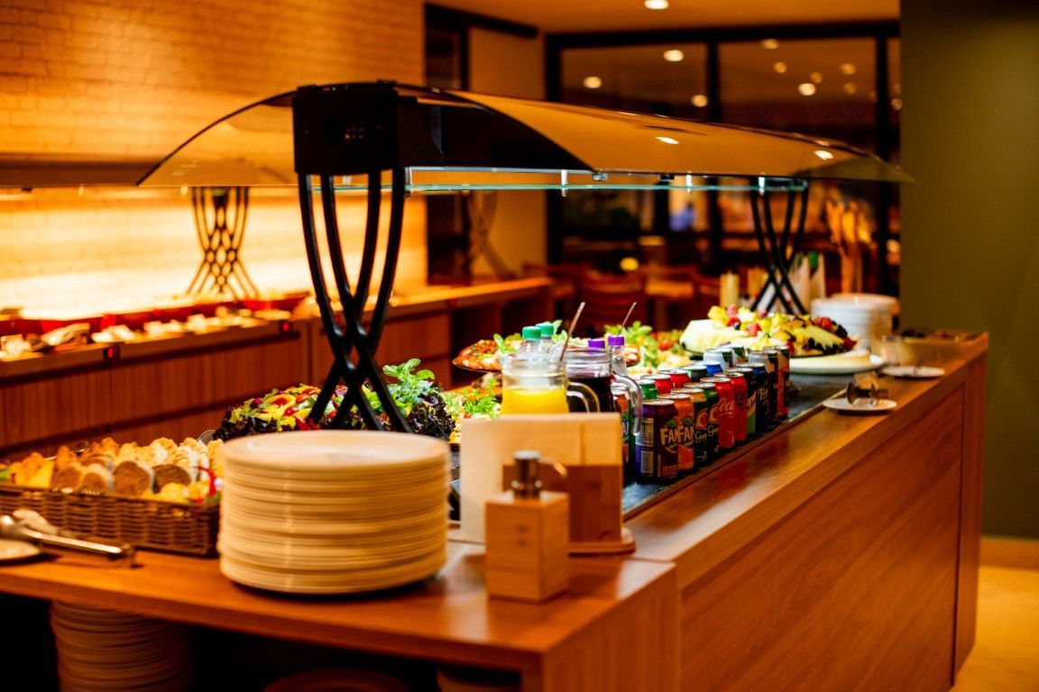 Uma mesa de bufê com pratos e garrafas de refrigerante