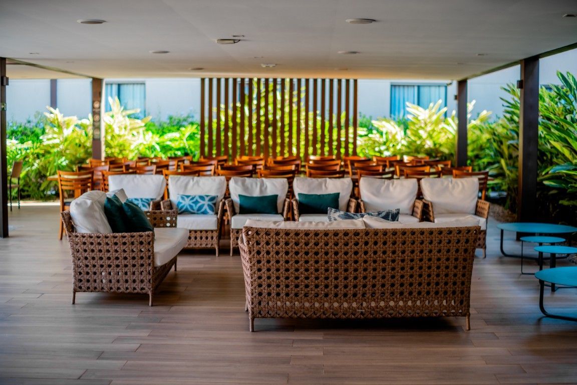 Uma sala de estar repleta de móveis e uma sala de jantar ao fundo.