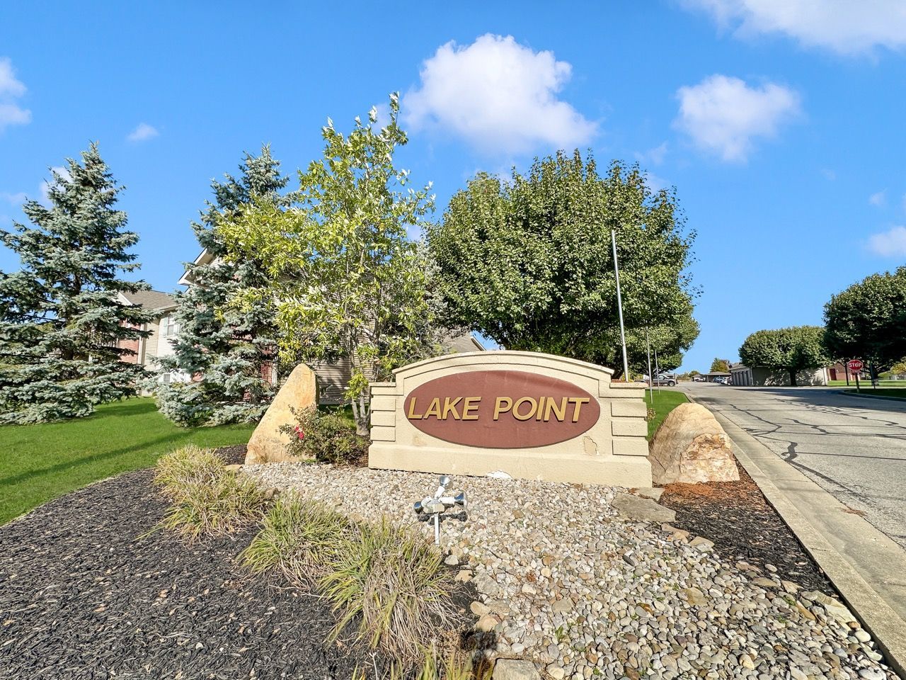 Sign for Lake Point community with trees and blue sky.