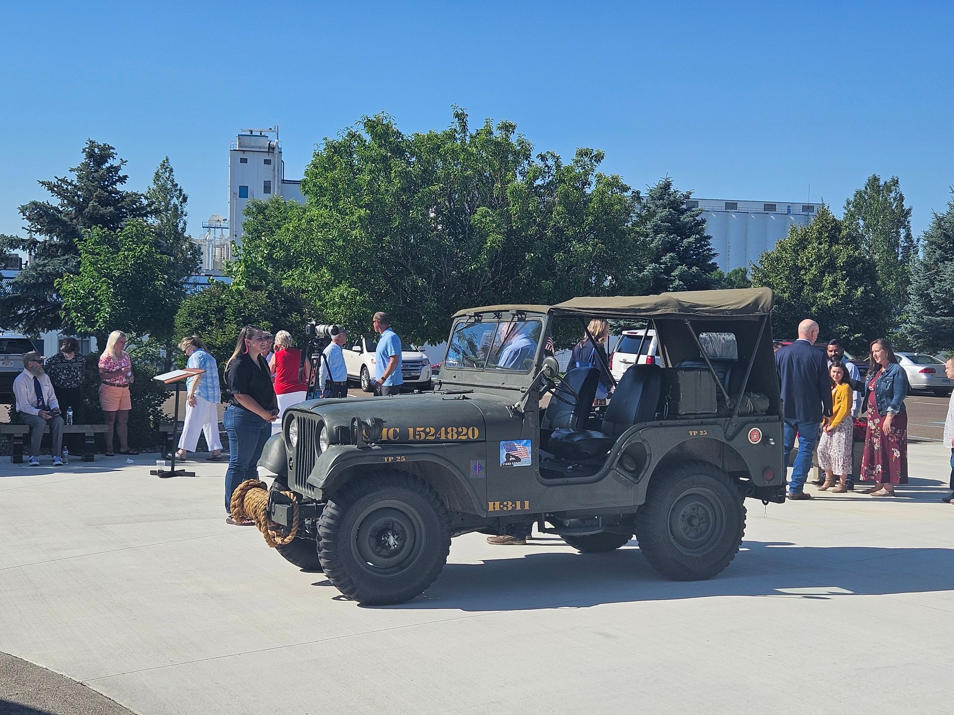 A group of people are standing around a jeep that says u.s. army on the side