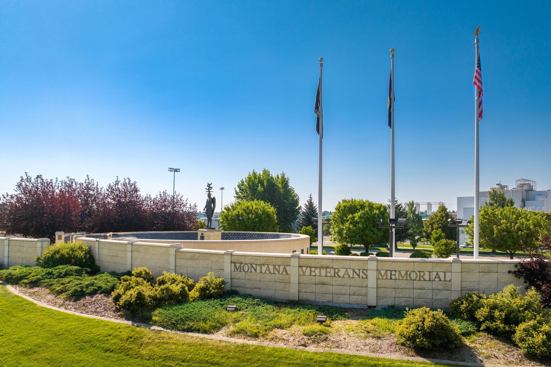 A montana veterans memorial is surrounded by grass and flags