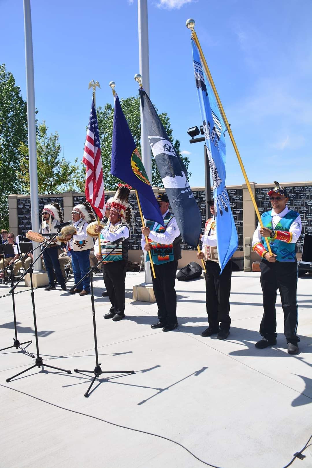 A group of people standing in front of a microphone holding flags.