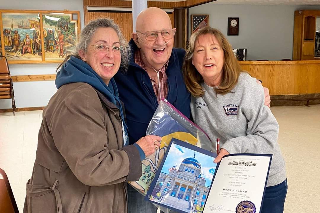 A man and two women are posing for a picture while holding a certificate.