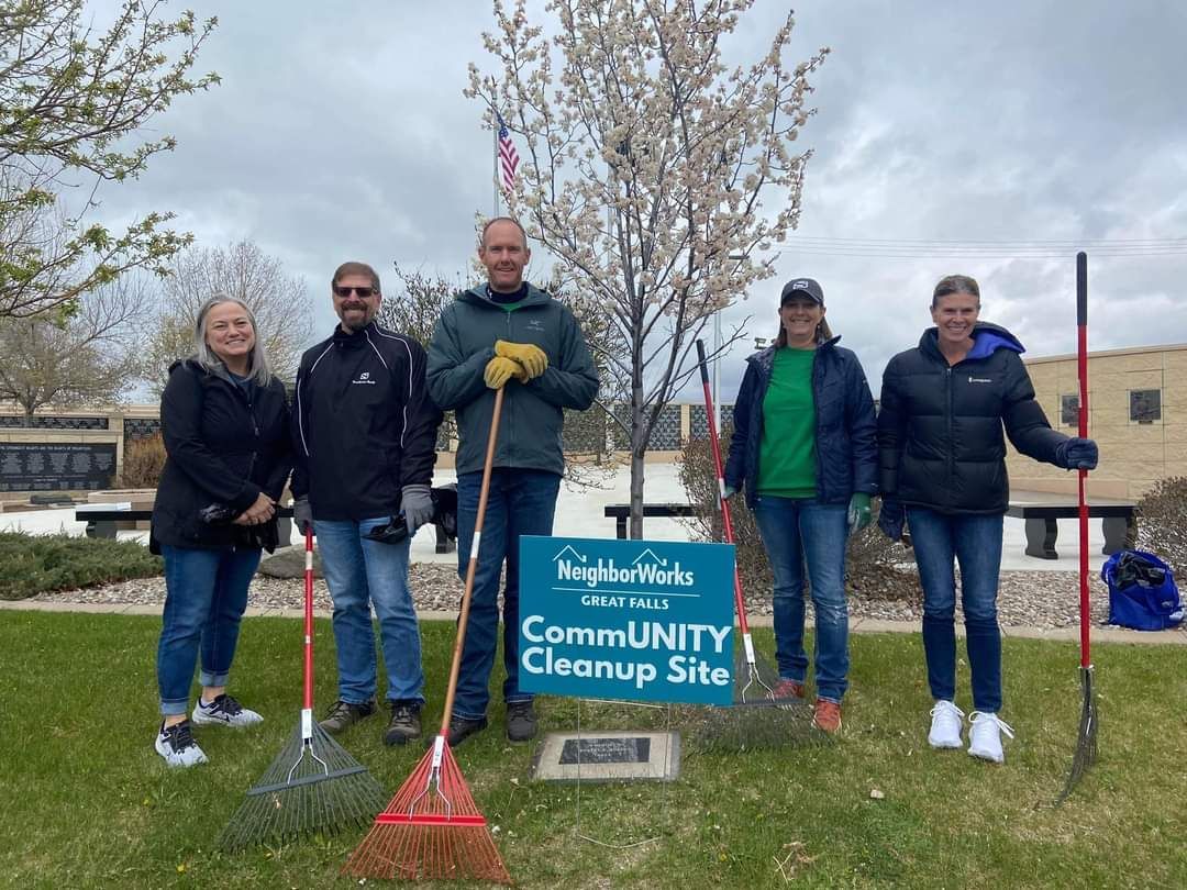 A group of people are standing in front of a sign that says community cleanup site.