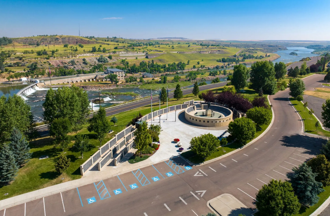 An aerial view of a park with a river in the background.