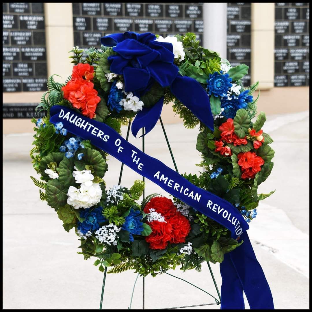 A wreath with a blue ribbon that says daughters of the american revolution