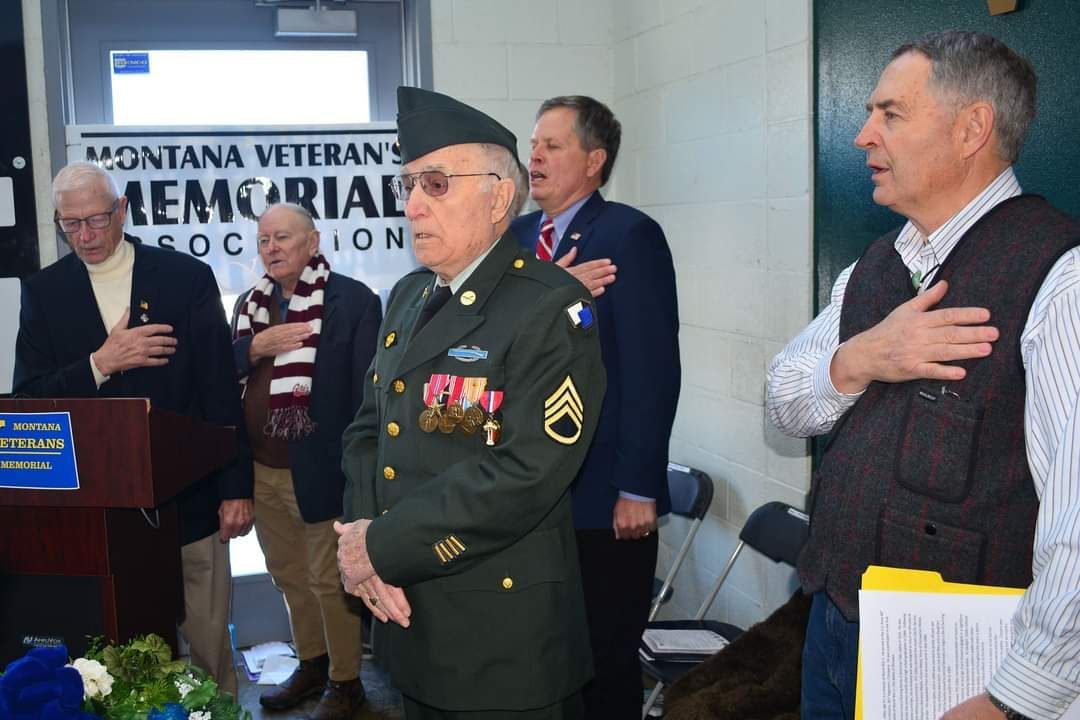 A group of men are standing in front of a sign that says montana veterans memorial