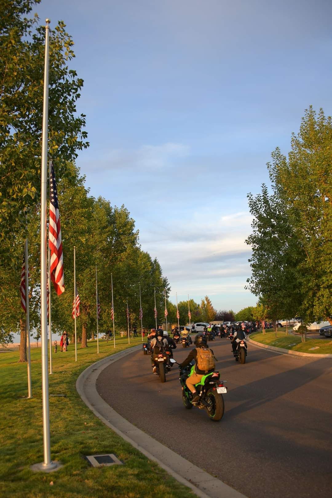 A sunset over a cemetery with a flag flying in the background.