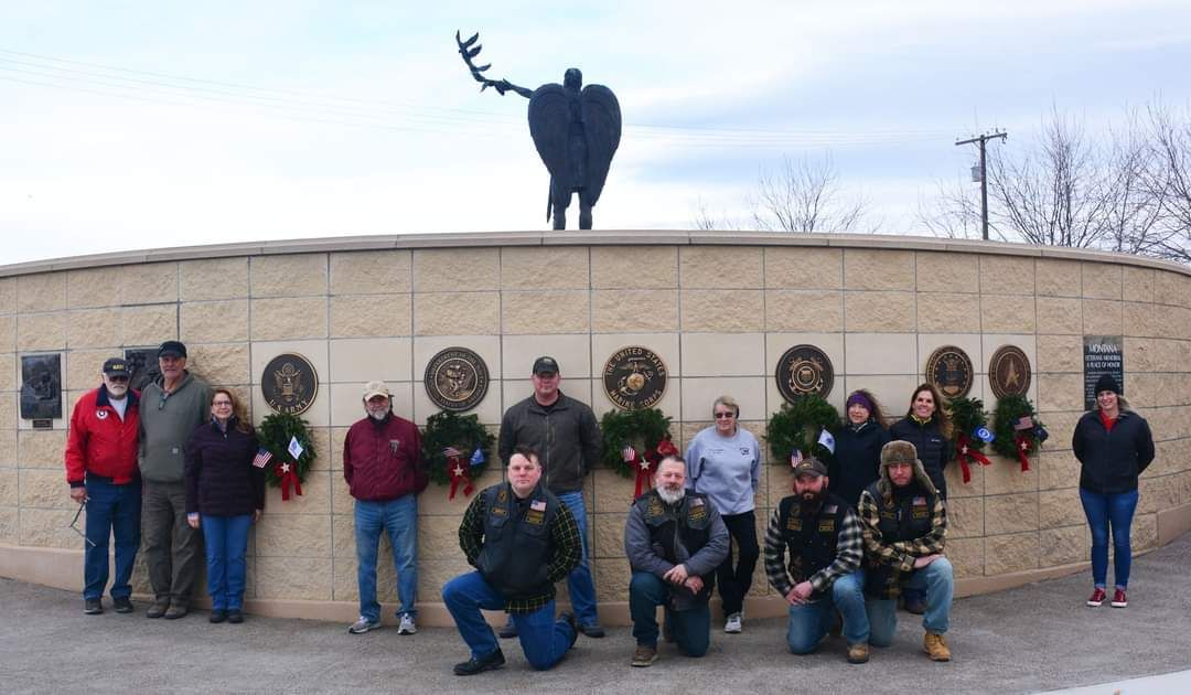 A group of people are posing for a picture in front of a statue