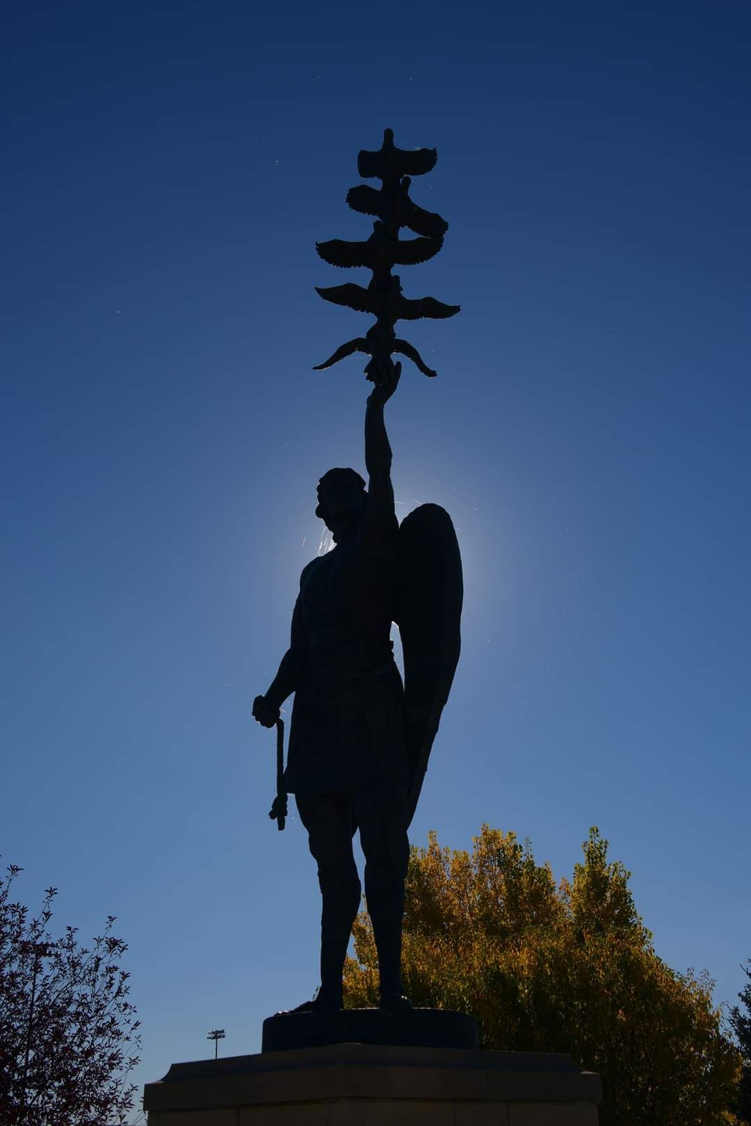 A statue of a man with wings holding a flag