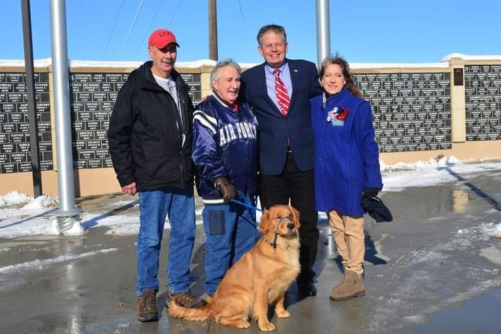 A group of people posing for a picture with a dog