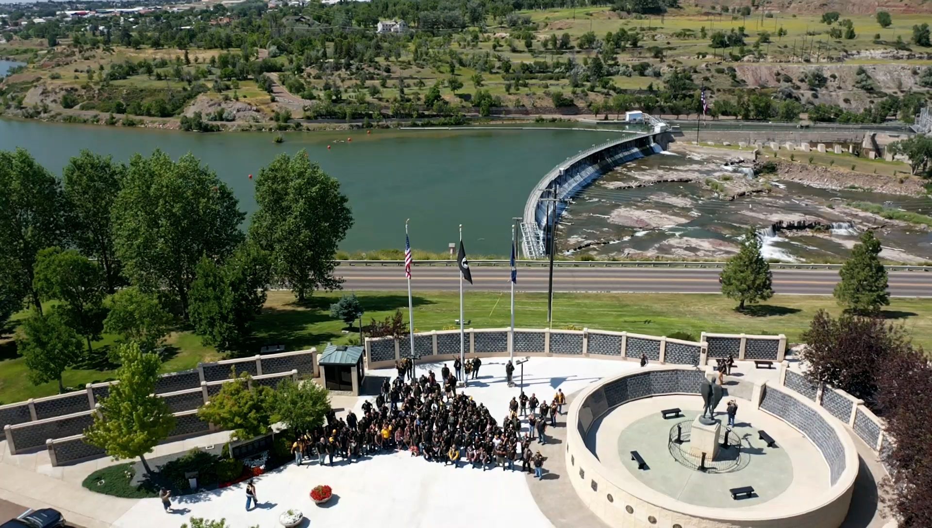 An aerial view of a group of people standing in front of a river
