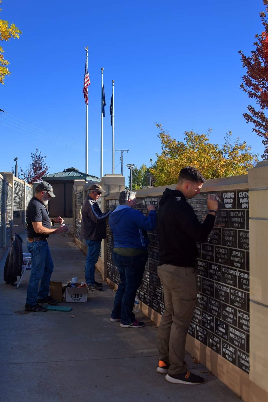 A group of people are writing on a wall.