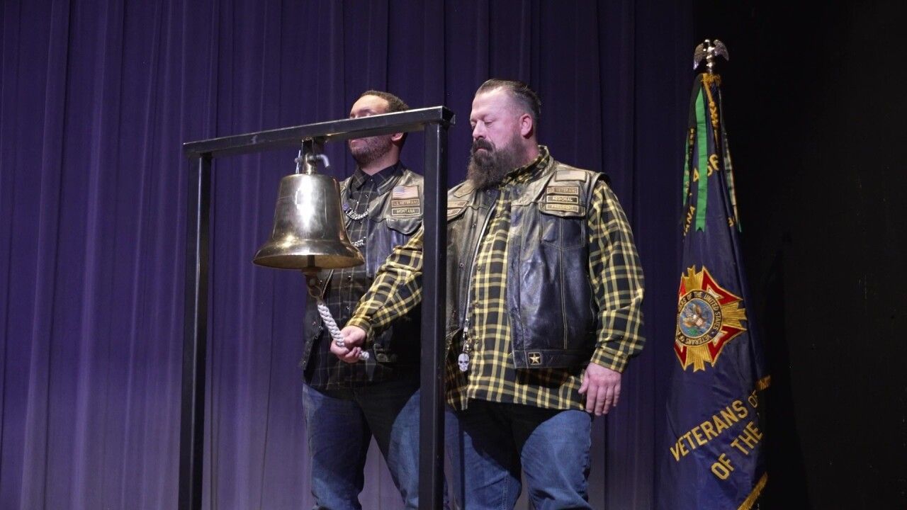 A group of people are sitting in chairs in front of a play button.