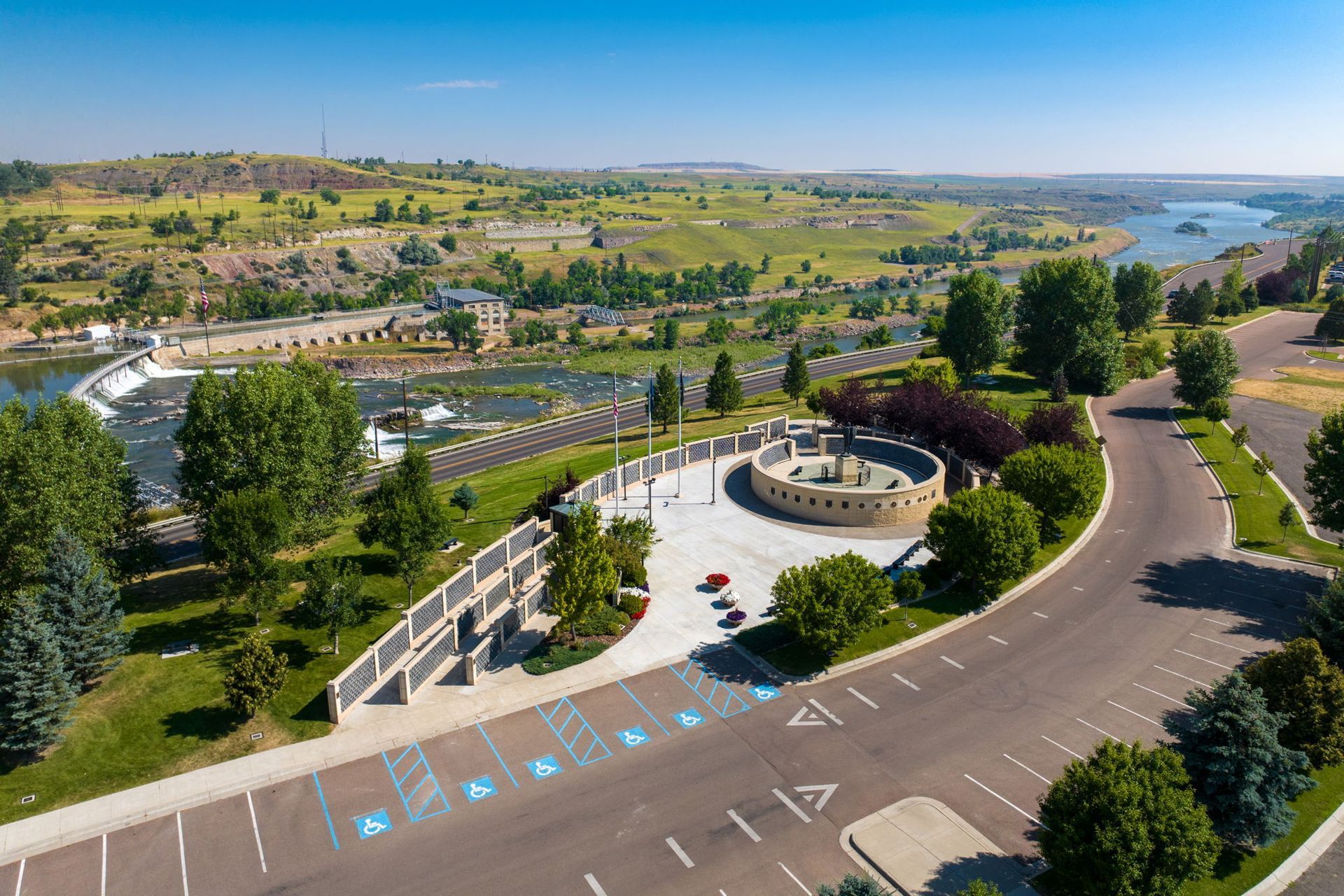 An aerial view of a park with a river in the background.