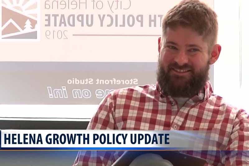 A man with a beard is sitting in front of a sign that says helena growth policy update.