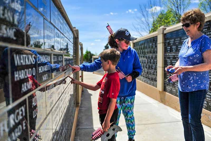 A group of people are putting flags on a wall.