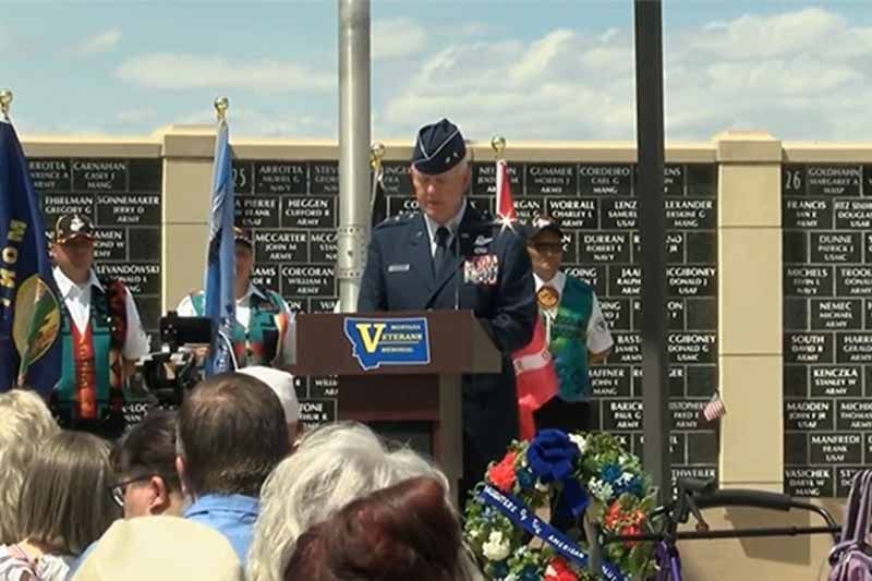 A man stands at a podium with the letter v on it