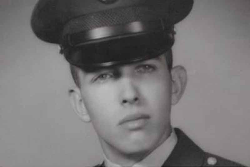 A black and white photo of a man in a military uniform.