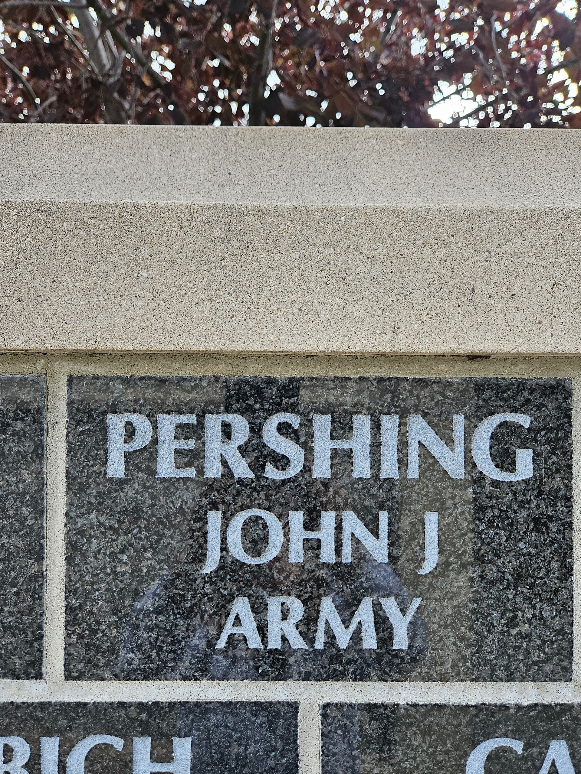 A brick wall with the name pershing john j army written on it