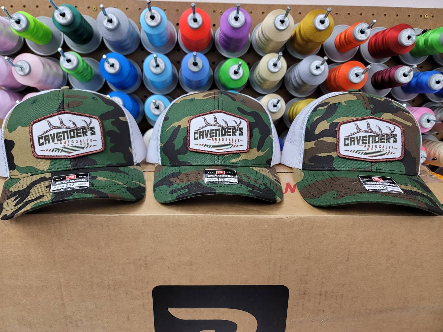 Three camouflage baseball caps with white mesh backs, 