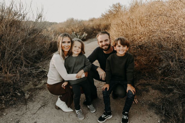 A family is posing for a picture on a dirt path.