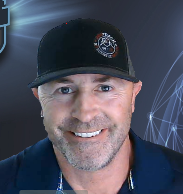 Man wearing a black hat with a logo, smiling, and looking at the camera.