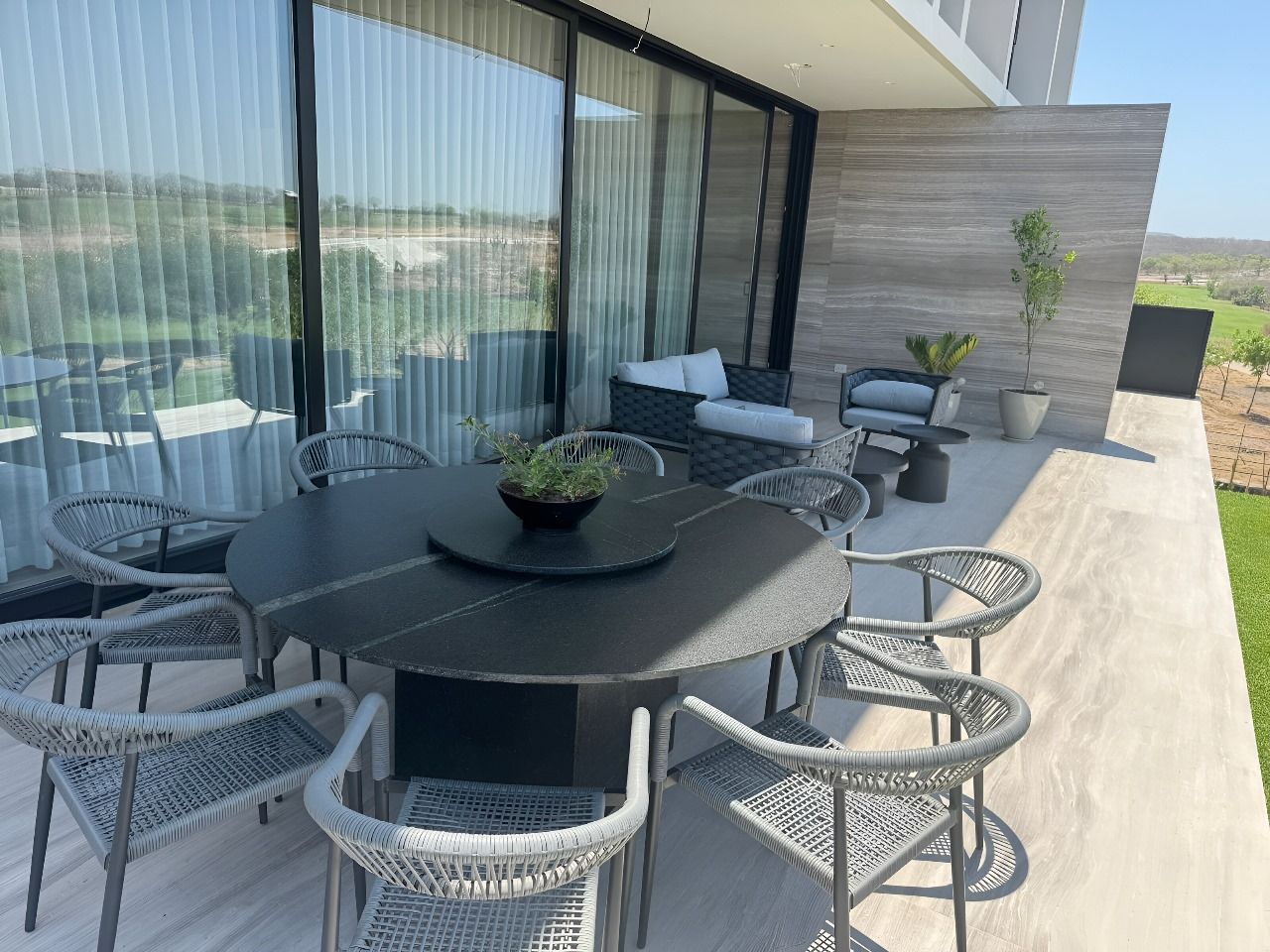 Hay una mesa y sillas en el patio de una casa.