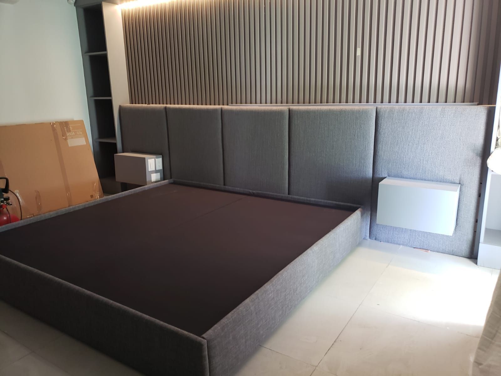 Una cama está sentada en una habitación al lado de una pared.