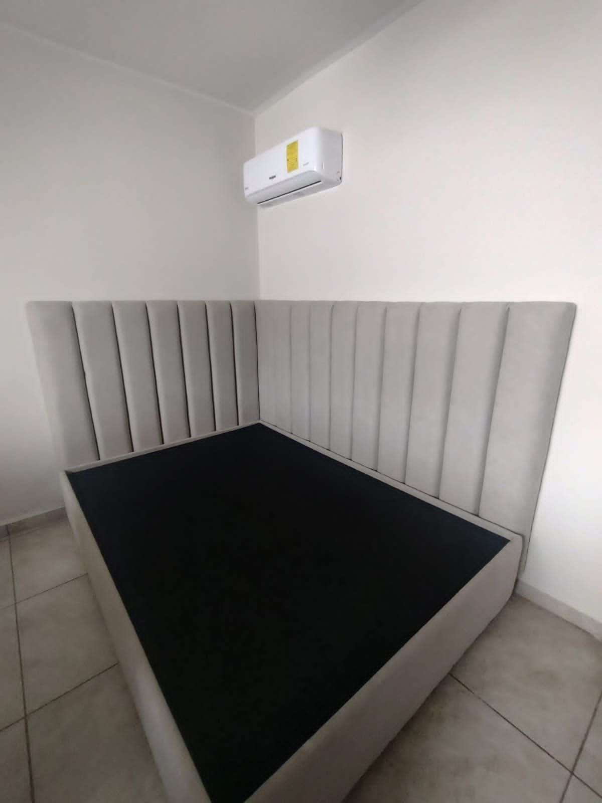 Un dormitorio con una cama y un aire acondicionado en la pared.