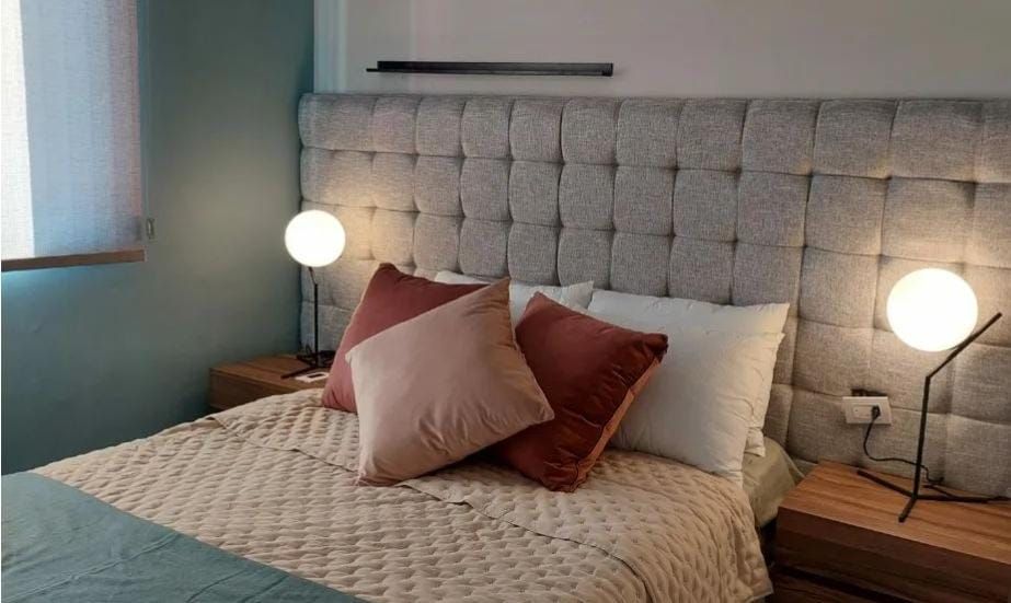 Una cama con cabecero y almohadas en un dormitorio.