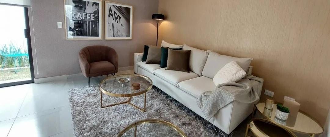 Una sala de estar con sofá, silla, mesa y alfombra.