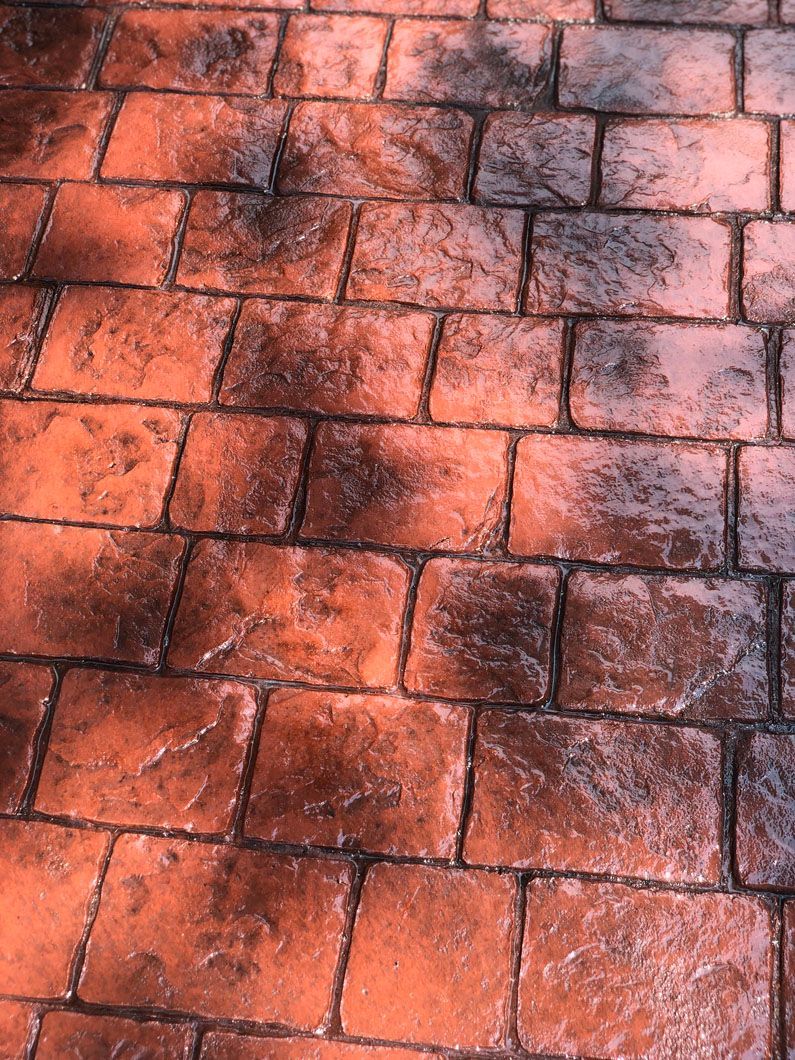 A close up of a brick walkway with a shadow on it.