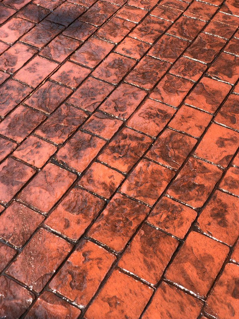 A close up of a brick floor with a shadow on it.