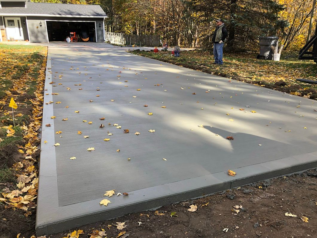 A concrete driveway is being built in front of a house.