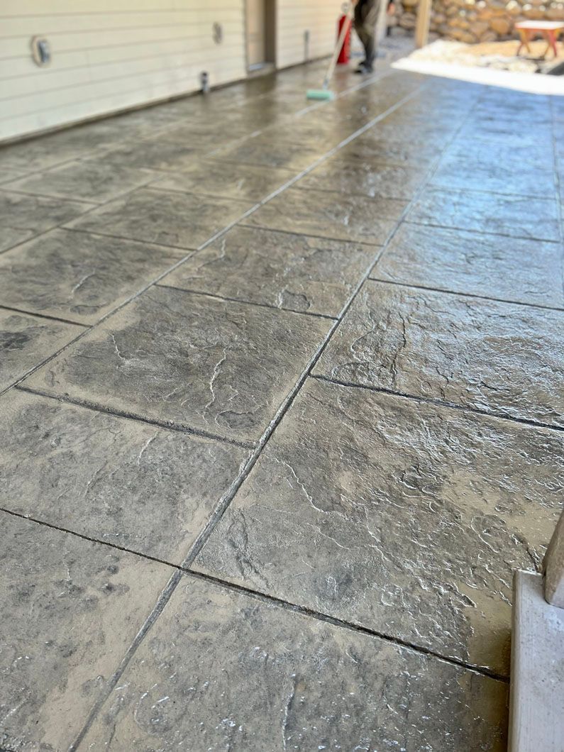 A person is cleaning a concrete floor in a garage.