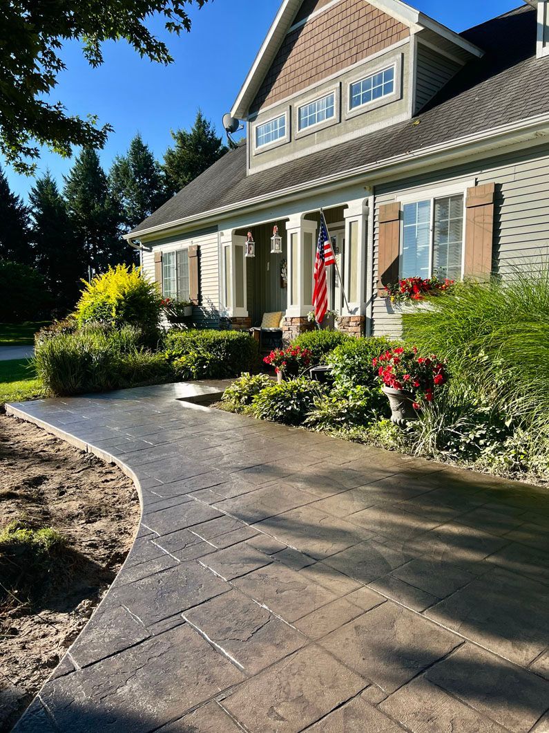 A large house with a concrete walkway leading to the front door.