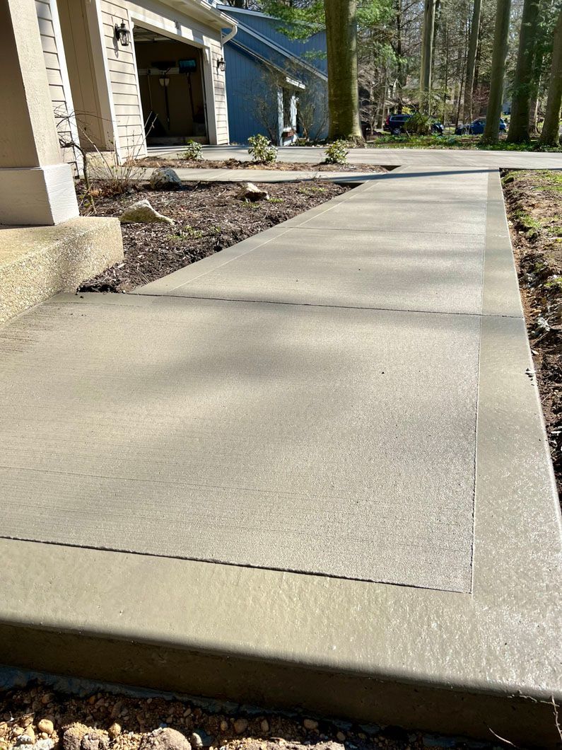 A concrete walkway is being built in front of a house.