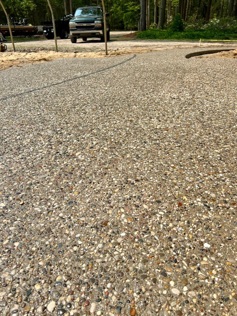 A car is parked on the side of a gravel road.