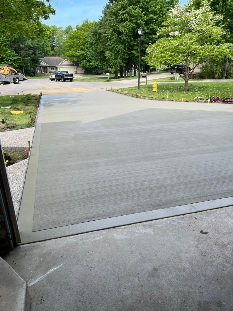 A concrete driveway with a fire hydrant in the middle of it.