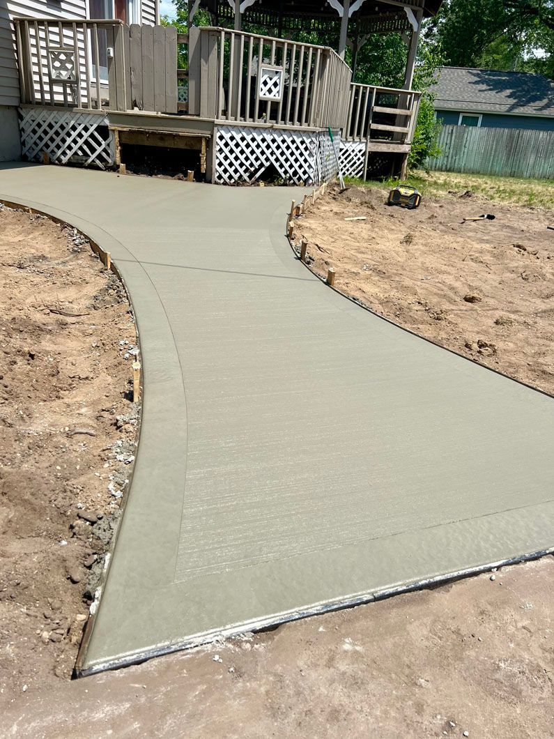 A concrete walkway is being built in front of a house.