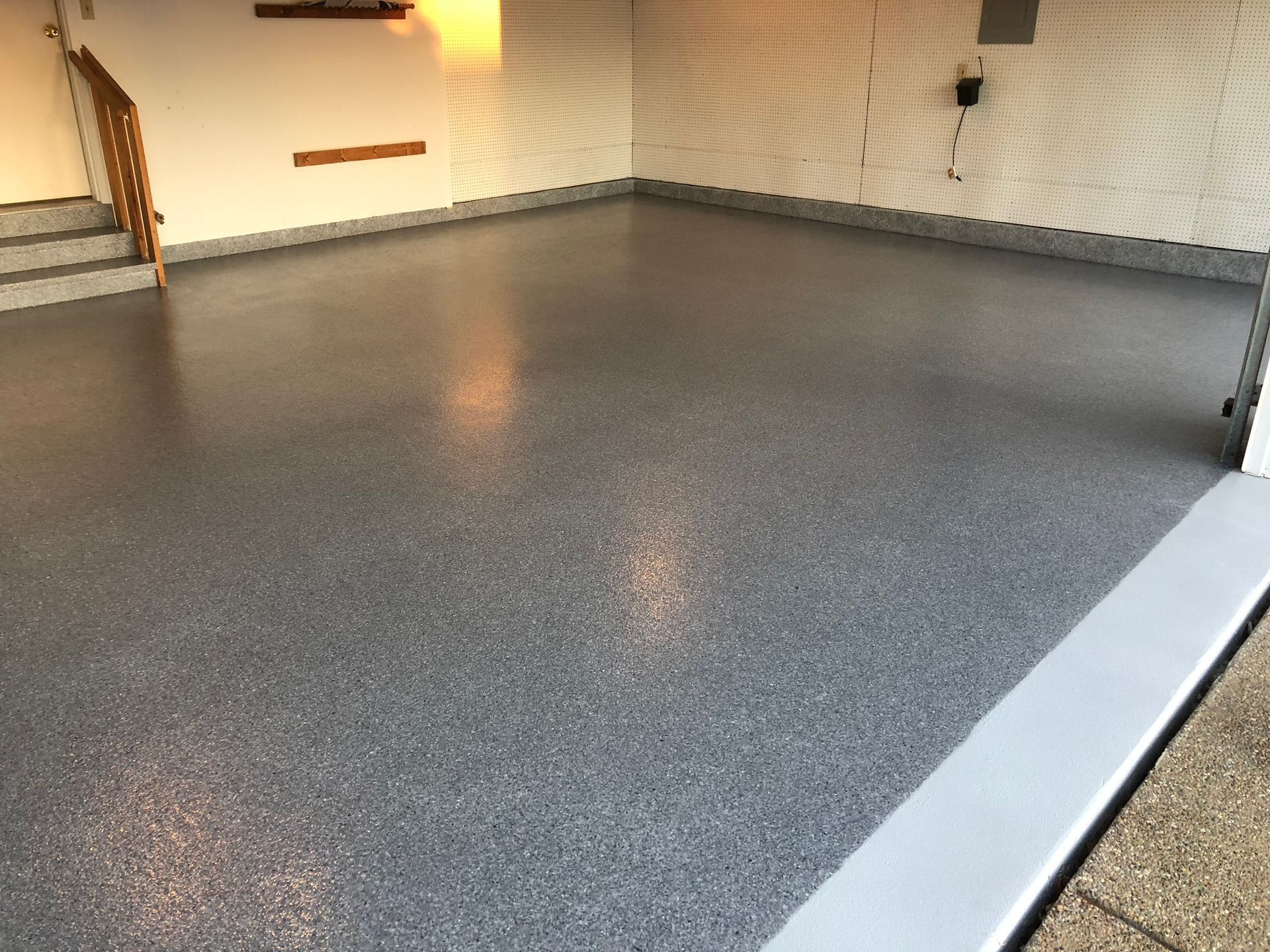 A garage with a concrete floor and stairs.