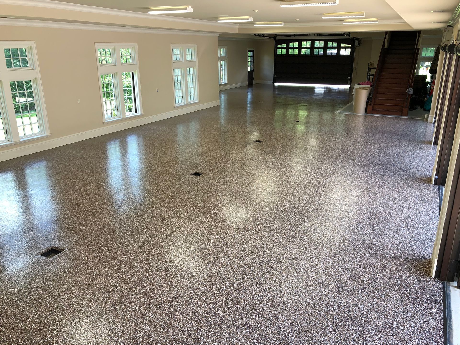 A large room with a staircase and a garage door.