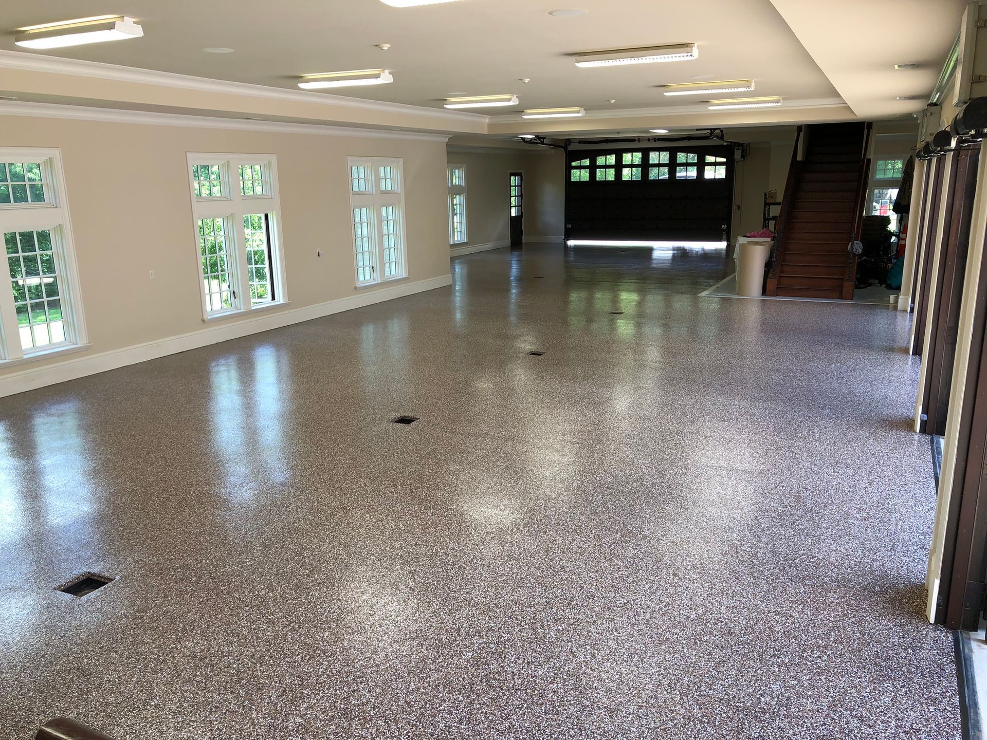 A large empty room with a concrete floor and a garage door.